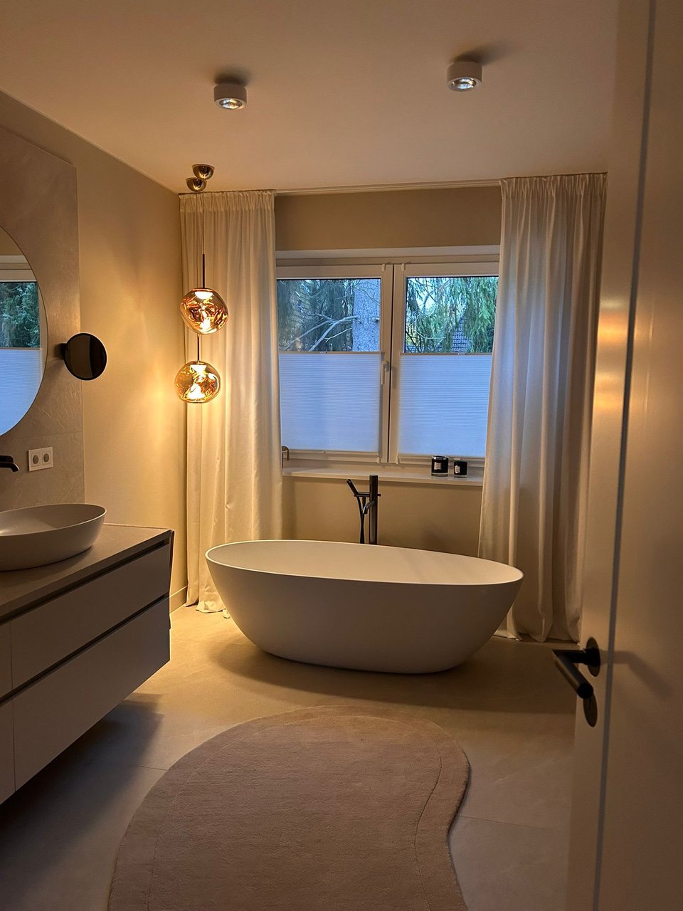 Badezimmer mit Vorhang und freistehender Badewanne